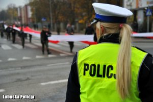 Policjantka ruchu drogowego- W tle harcerze z biało-czerwoną flagą