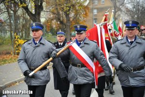 Policjanci z pocztu sztandarowego maszerują