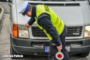 Policjant ruchu drogowego sprawdza oświetlenie pojazdu