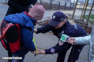 policjantka wręcza uczniowi odblaski