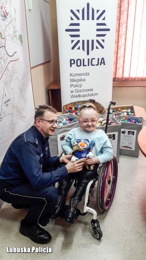 policjant wręcza dziewczynce maskotkę