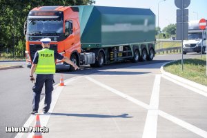 Policjant zatrzymuje ciężarówkę do kontroli.