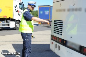 Policjant kontroluje autokar.