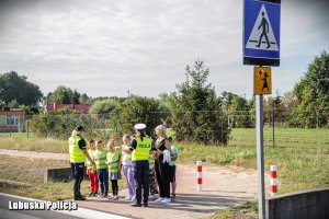 Policjantki z uczniami na przejściu dla pieszych.