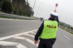 Policjant zatrzymuje pojazd do kontroli drogowej.