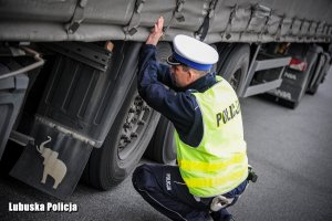 Policjant sprawdza stan techniczny pojazdu.