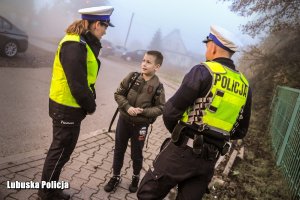 Policjanci rozmawiają z uczniem.