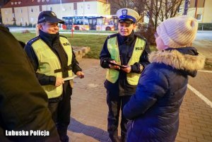 policjantki rozmawiają z pieszymi i wręczają odblaski