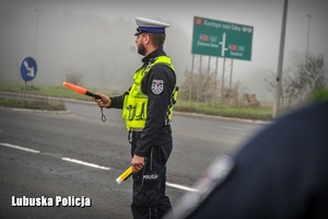 policjant zatrzymuje pojazd do kontroli drogowej