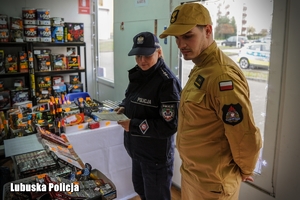 policjantka i strażak podczas kontroli sprzedaży fajerwerków