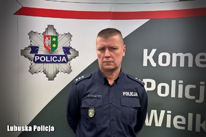 policjant przed banerem