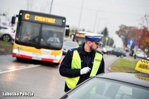 policjant, w tle autobus