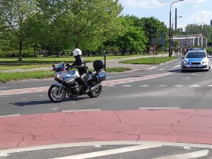 policjant na motorze prowadzi również uczestników masy rowerowej