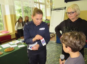 Policjantka pyta uczestnika turnieju, aby powiedział co to znak, który pokazuje.