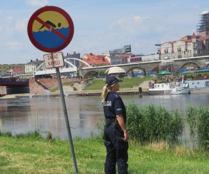 policjantka przy znaku z zakazem kąpieli