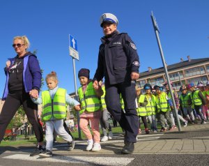 Policjantka przeprowadza dzieci przez pasy.