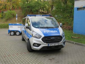 Nowy radiowóz Ford transit wraz z przyczepką do przewozu psów służbowych.