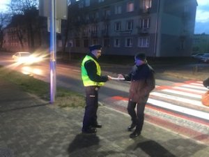 policjant wręcza pieszemu odblask