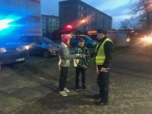 policjant wręcza pieszym odblask