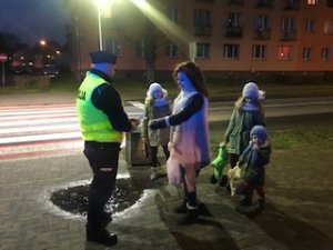 policjant wręcza pieszym odblask