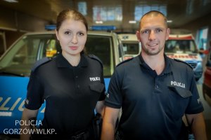 policjant i policjantka, w tle radiowóz