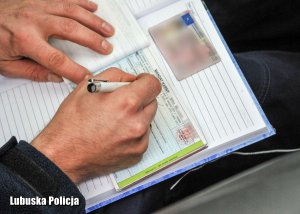 policjant wypisuje mandat karny,