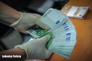 zabezpieczone banknoty euro trzymane w rękach