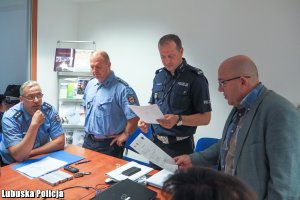 policjant i inne osoby na spotkaniu w sali