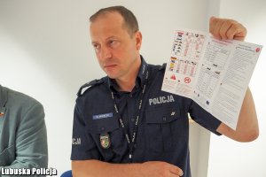 policjant prezentuje ulotkę z przepisami