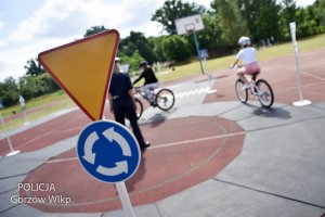 znak drogowy, w tle policjantka i rowerzyści