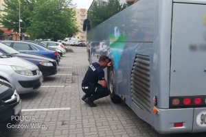 policjant kontroluje stan opon autokaru