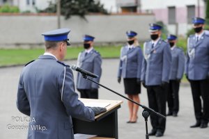 przemawia komendant, w tle awansowani policjanci