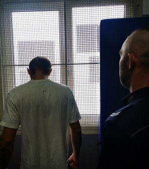Na zdjęciu jest zatrzymany, który przebywa w pomieszczeniu dla osób zatrzymanych.