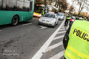 policjanci na drodze, jadące auta i autobusy