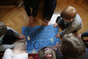 Policjantka z dziećmi na podłodze   robią plakat