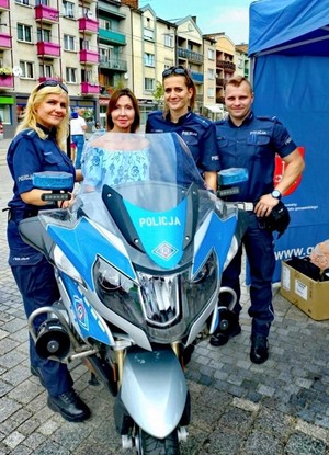 na zdjęciu stoi troje policjantów przy motocyklu