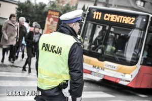 Policjant drogówki, a w tle autobus.