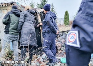 Policjanci i inne osoby podczas sprawdzania miejsc, gdzie mogą przebywać osoby bezdomne.