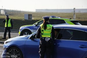 policjant ruchu drogowego na drodze bada trzeźwość kierującego pojazdem