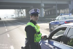 policjant ruchu drogowego na drodze bada trzeźwość kierującego pojazdem