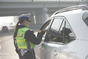 policjant ruchu drogowego na drodze bada trzeźwość kierującego pojazdem