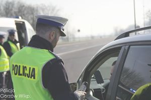 policjant ruchu drogowego na drodze bada trzeźwość kierującego pojazdem