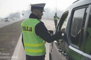 policjant ruchu drogowego na drodze bada trzeźwość kierującego pojazdem
