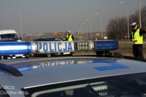 policjant ruchu drogowego na drodze bada trzeźwość kierującego pojazdem