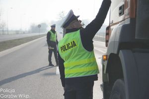 policjant ruchu drogowego na drodze bada trzeźwość kierującego pojazdem